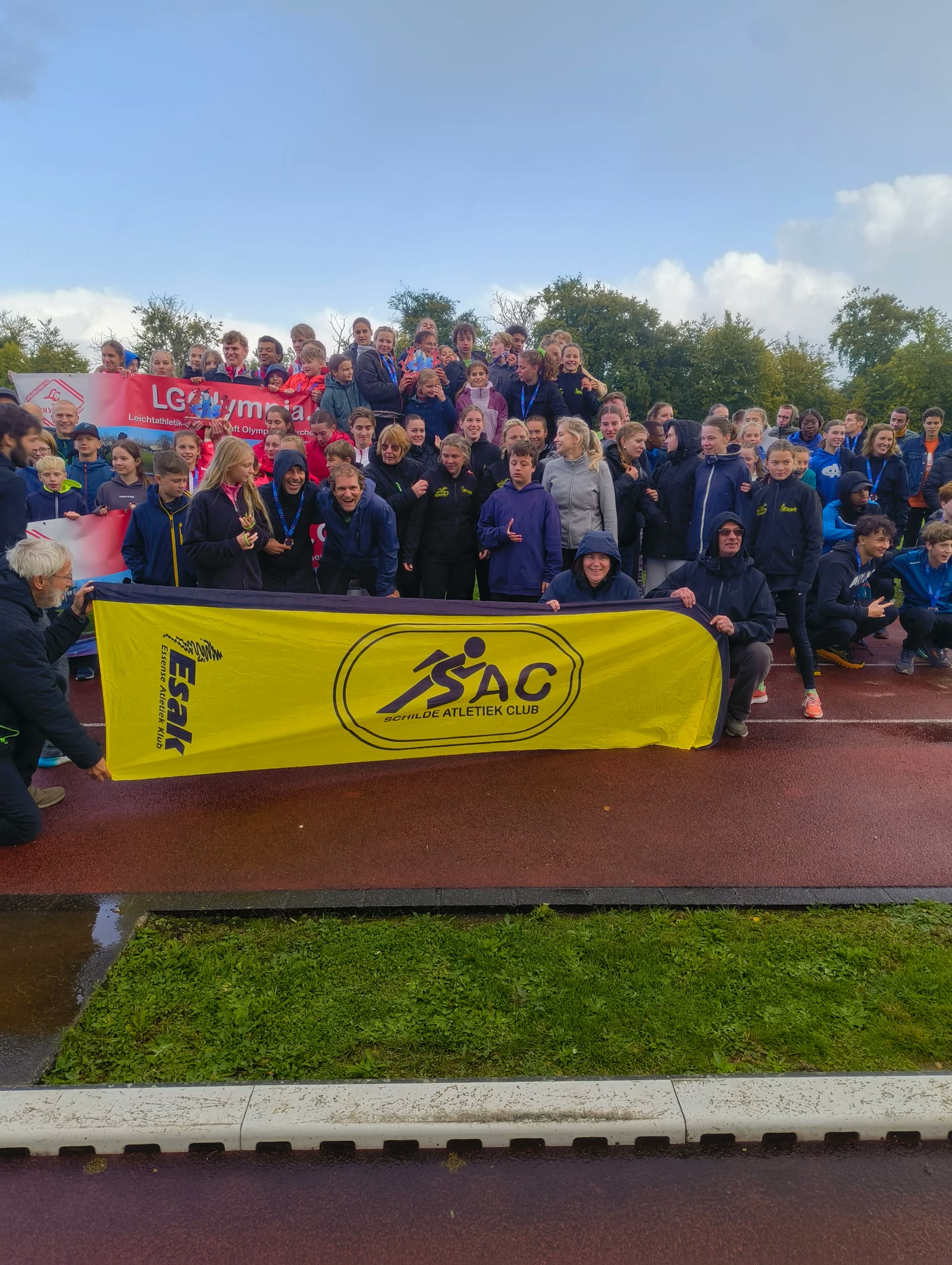 SAC-atleten samen op de piste met de clubvlag